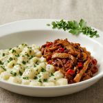 O farfurie albă adâncă ce conține două preparate distincte: în stânga, cubulețe de gulii într-un sos alb cremos cu pătrunjel, iar în dreapta, o tocăniță de ciuperci Pleurotus bine rumenită, servite cu tacâmuri pe o masă texturată.